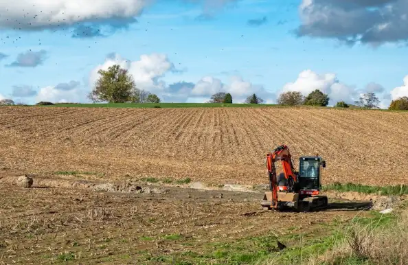 Mini excavator working in an agricultural field