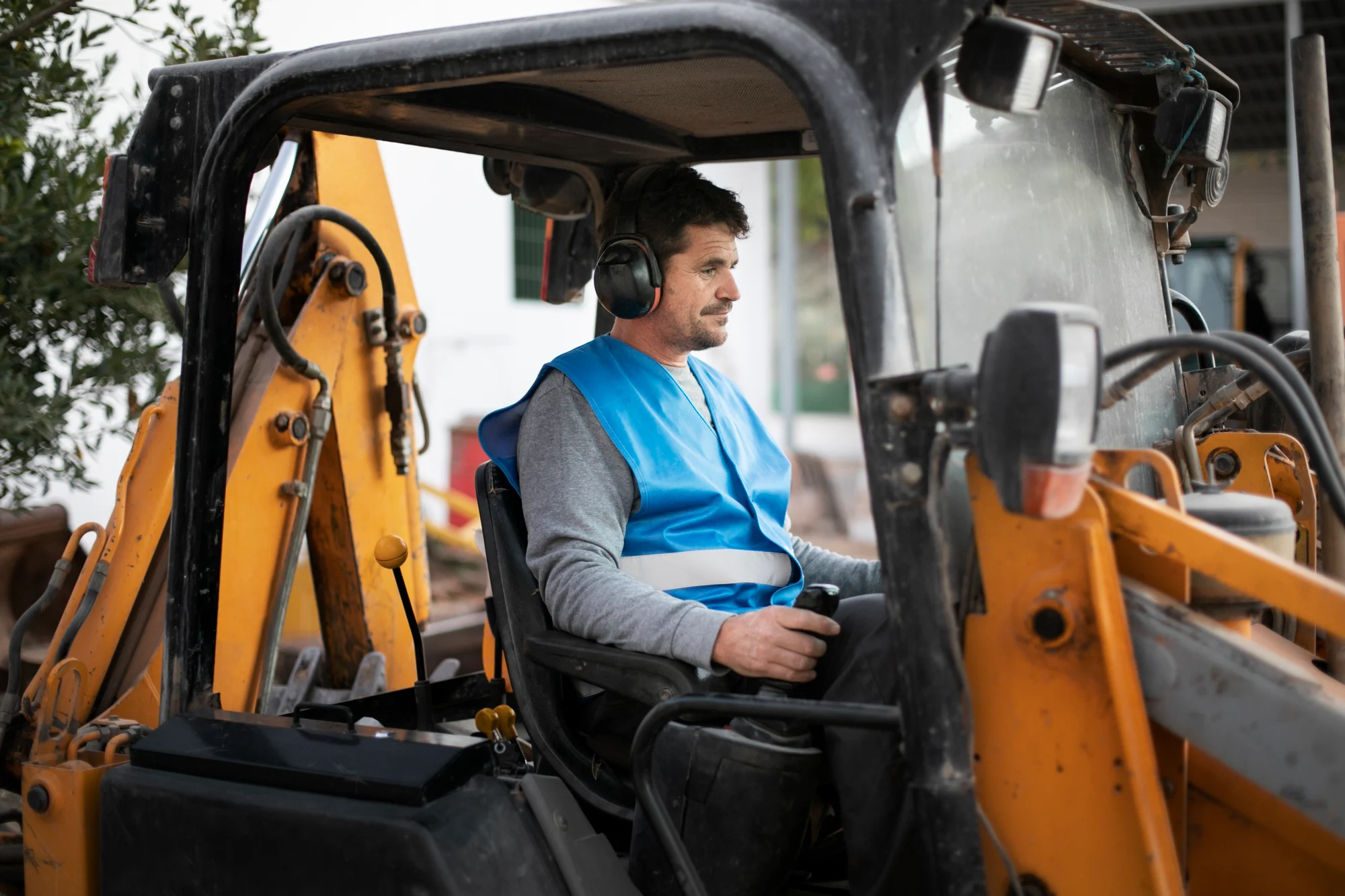 Mini excavator bucket digging in wet muddy soil
